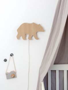 a wooden bear decoration next to a baby crib