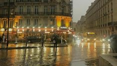 people are walking down the street in the rain