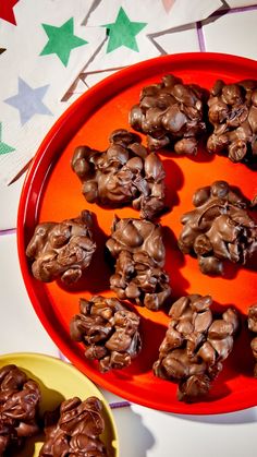 chocolate covered cookies on an orange plate next to two yellow plates with green and white stars