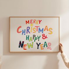 a person holding up a christmas card with the words merry christmas and happy new year