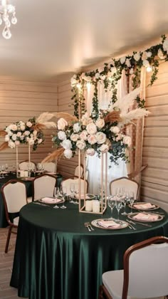 the tables are set with green cloths and white flowers