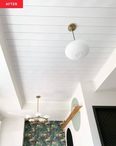 the ceiling in this room is decorated with green and white wallpaper, along with an animal print rug