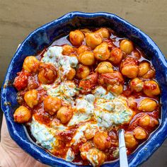 a blue bowl filled with meatballs covered in sauce