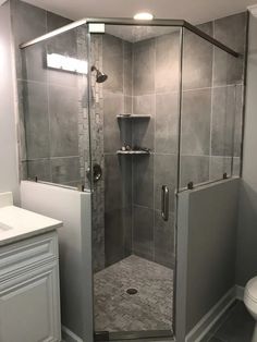 a bathroom with a walk in shower next to a toilet