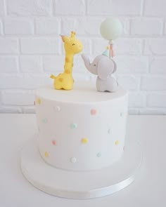 a white cake with an elephant and giraffe on top