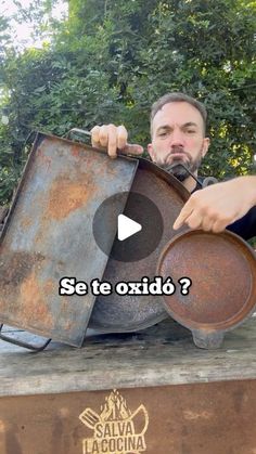 a man is holding an old frying pan