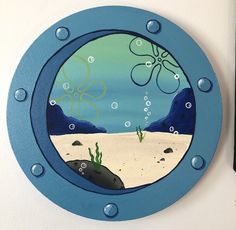 a blue porthole with an octopus and seaweed in the water on it's side