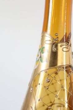 a close up view of the inside of a wine bottle with gold decoration on it