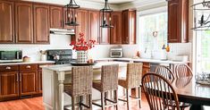 a kitchen filled with lots of wooden cabinets and counter top space next to a dining room table