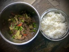 two metal bowls filled with rice and veggies