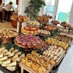 an assortment of sandwiches and pastries on display in a buffet style area at a restaurant