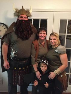 a family is dressed up as viking and his wife are posing for a photo with their son