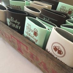 a wooden box filled with lots of coffee mugs on top of a white table