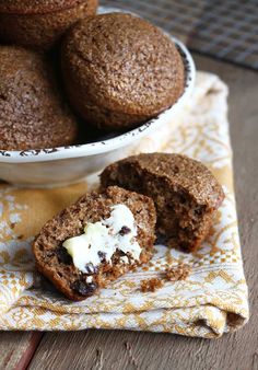 some muffins are sitting on a napkin next to a bowl of other muffins