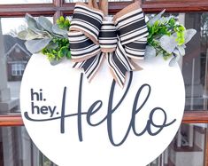 a door hanger that says hi hey hello with a bow hanging on the front