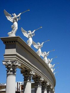 the statues are all lined up on top of each other in front of a blue sky