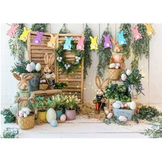 an assortment of fake bunnies and plants in front of a wall with bunny decorations