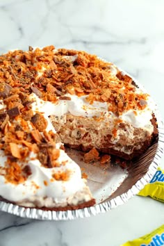 a cake with white frosting and toppings sitting on top of a table next to a candy bar