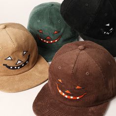 four hats with faces painted on them sitting next to each other, all in different colors