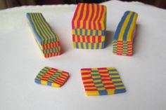 four different colored blocks sitting on top of a white table