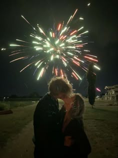 a man and woman kissing in front of a firework display at the end of their night