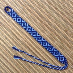 a piece of woven material sitting on top of a bamboo floor next to a pair of scissors