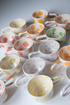 many bowls and spoons are lined up on the table together, all with different designs