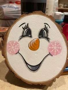 a painted wood slice with a smiling face