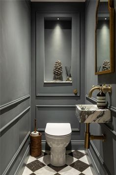 a bathroom with a toilet, mirror and checkered flooring on the walls is shown