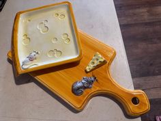 a wooden tray with cheese and mice on it