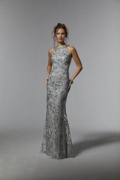 Name: Embroidered Net Sheath with Gunmetal BeadingSultry evening gown skims the body in a fitted sheath silhouette with a halter neckline that shows off your arms and shoulder and a beautiful illusion back. The embroidered net features an abstract pattern with the subtle sparkle of edgey gunmetal beading. Matching stole included. Halter Evening Dress, Madeline Gardner, Beaded Evening Gowns, Mother Of The Bride Dresses Long, Mother Of The Bride Gown, Formal Dresses With Sleeves, Mother Of Groom Dresses, Mob Dresses, Mori Lee