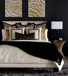 a bedroom with black and gold decor on the wall above the bed is decorated with zebra prints