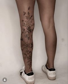 a woman's legs with flowers and leaves on them