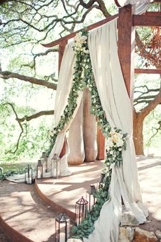 an outdoor ceremony setup with white flowers and greenery