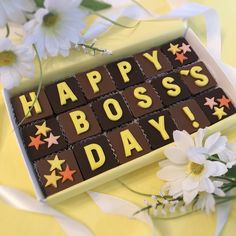 a happy boss's day chocolate box with flowers and daisies in the background