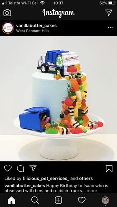 a white cake with gummy bears on top and a truck in the middle is featured for instagram