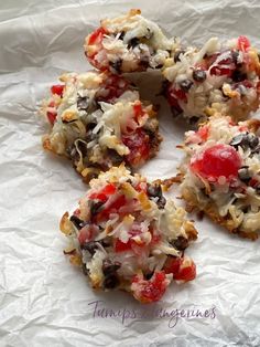 four cookies with toppings sitting on top of white paper