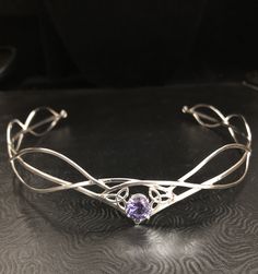 I have fabricated a sterling silver Celtic and Elvish inspired bridal tiara which is designed to be worn for a wedding, a Renaissance event, or hand-fasting ceremony. An artisan circlet with a Middle Earth feel! This piece will fit 3/4's around the head and is tied off, in the back, by an elastic jeweler's cord so that it will remain snug and in place while in motion. This works better than using a chain link, which can leave a circlet too tight or just slightly too loose. This way, you tie it o Silver Adjustable Crown With Pinched Shape, Adjustable Silver Wedding Crown, Silver Wedding Crown With Pinched Shape, Silver Crown Headpiece For Wedding, Elegant Adjustable Silver Crown, Silver Teardrop Crown Headpiece, Silver Headpiece With Tall Crown Design, Adjustable Crown Design Headpiece For Weddings, Sterling Silver Crown Design Jewelry For Wedding