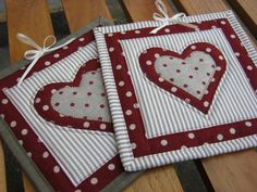 two red and white hearts are sitting on a bench