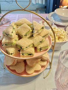 there are many sandwiches on the table with cups and glasses next to eachother