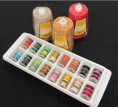 an assortment of different colored crayons in a container on a black table top