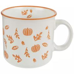 an orange and white mug with pumpkins on it