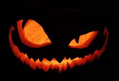 a carved pumpkin with glowing eyes in the dark