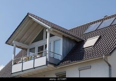 an apartment building with solar panels on the roof and balconies on the second floor