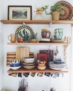 the shelves are filled with plates, bowls and utensils