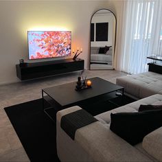 a living room filled with furniture and a flat screen tv on top of a wall