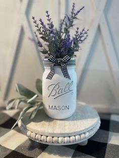 a white mason jar with purple flowers in it