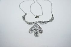 Vintage silver filigree cannetille necklace with clear rhinestone accents. Silver is untested due to the delicateness of the piece, but is likely 800 silver and Italian or German in origin. Victorian Silver Necklace With Diamond Accents, Antique Silver Necklaces With Diamond Accents, Art Deco Silver Necklace With Filigree, Silver Filigree Necklaces For Jewelry Making, Vintage Sterling Silver Necklaces With Diamond Accents, Vintage Sterling Silver Necklace With Diamond Accents, Art Deco Silver Metal Necklace, Ornate Silver Necklace With Delicate Design, Victorian Silver Filigree Necklace