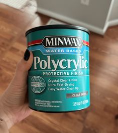 a person holding up a can of polycrylic