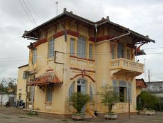 an old yellow building with two balconies on the second floor and one story